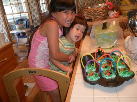 Girls making Easter basket cupcakes